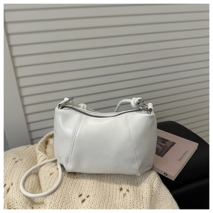 Detail of white half-moon shoulder bag showing vertical stitching and silver zipper closure
