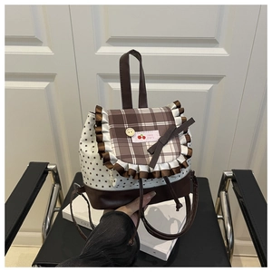 Detail view of small plaid backpack with lace ruffles, bow knots and star patterns