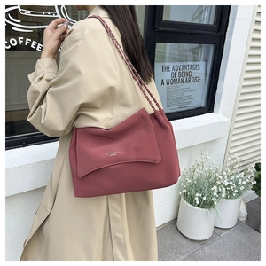 Detail of rose pink matte leather shoulder bag with chain strap and embossed text
