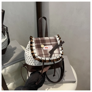 Detail of sweet plaid backpack with lace trim, cherry label and star patterns