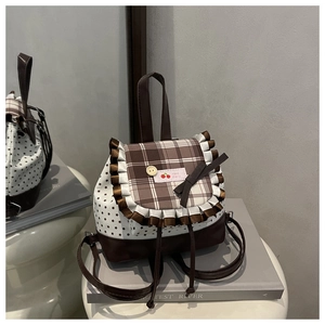Detail of sweet school backpack with star pattern, lace trim, and plaid button flap