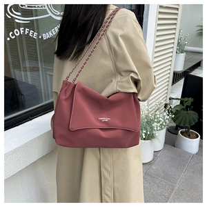 Detail of deep pink leather shoulder bag with chain strap and fashion lettering