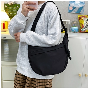 Casual black nylon crescent bag worn crossbody with woven cord detail and wide strap