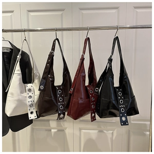 Detail of four colorful faux leather shoulder bags with large metal eyelets on straps