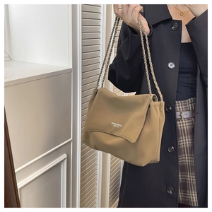 Detail of khaki nylon tote bag featuring silver chain strap and fashion lettering