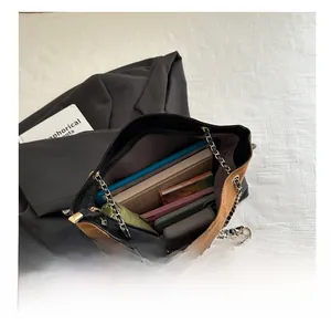Brown suede tote bag interior showing capacity with a tablet, book, and daily essentials