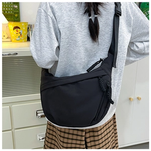 Detail of black nylon crossbody bag with adjustable wide strap and woven zipper pull