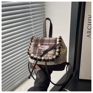 Detail of mini backpack with star prints, lace plaid flap and cherry embroidery patch