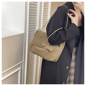 Detail of khaki shoulder bag with silver chain strap and fashion typography on nylon