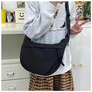 Detail of black nylon crescent crossbody bag featuring unique woven rope zipper puller