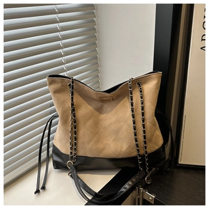 Detailed view of khaki quilted suede and black faux leather tote with golden chain