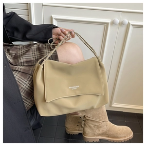Detail of khaki leather shoulder bag with metal chain strap and fashion logo lettering