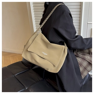 Detailed view of beige leather shoulder bag with chain strap and printed lettering