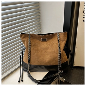 Detail of quilted leather patchwork tote bag with metal lock and chain strap