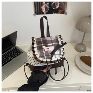 Detail of cute plaid backpack featuring lace trim, bow knot, and star patterns