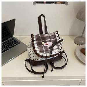 Detail of sweet pleated rucksack with cherry label, plaid flap and star prints