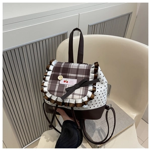Detail of sweet plaid backpack with star print, lace trim, and ribbon bow decoration