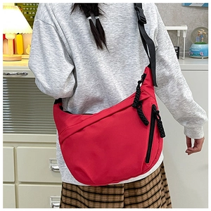 Close-up of red large-capacity crescent crossbody bag with durable black zipper detail