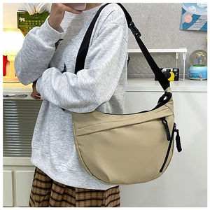 Close-up of khaki crescent crossbody bag featuring smooth zipper and adjustable strap