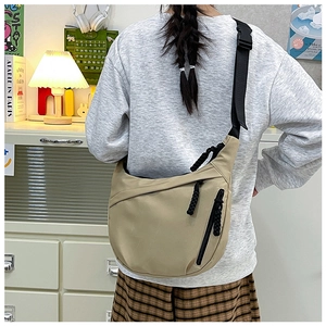 Detail of khaki nylon dumpling bag featuring adjustable wide strap and plastic buckle