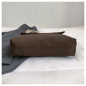 Detailed close-up of coffee brown matte leather tote bag with sturdy double-row stitching