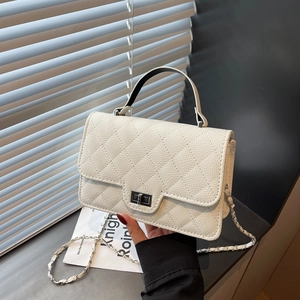 Sac à bandoulière en cuir blanc matelassé avec fermoir argenté et chaîne en métal porté à la main