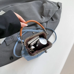 Retro denim bucket bag with leather handle showing interior capacity and metal clasp