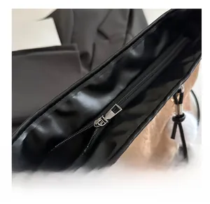 Detail shot of smooth silver metal zipper and black textured leather on the large tote bag