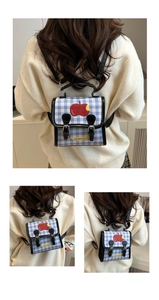 Detail of blue and white checkered backpack with apple print and faux leather handle