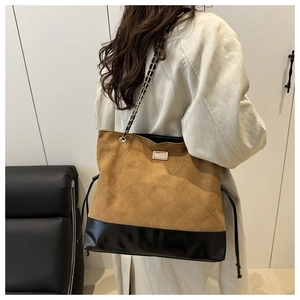 Detail of diamond quilted suede tote bag with chain strap and elegant patchwork design