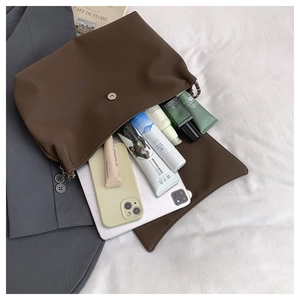 Interior storage space of the large vintage shoulder bag showing tablet and cosmetics