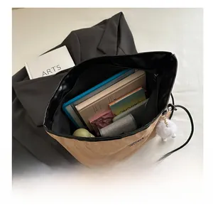 Interior view of khaki tote bag showing large capacity for books and tablet with fuzzy charm