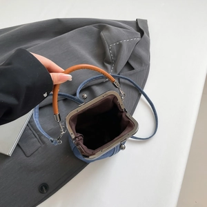 Retro denim bucket bag with metal clasp and brown top handle shown from top view