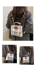 Detail of blue plaid backpack with apple pattern and yellow label in lifestyle setting