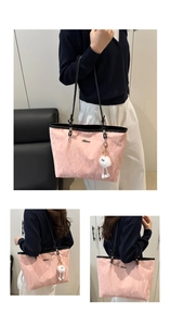 Detailed view of pink textured tote bag with metal logo, plush charm and black straps