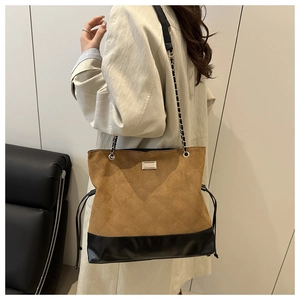 Detail of brown quilted suede and black leather patchwork tote with chain strap