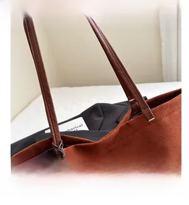 Close-up of caramel suede tote bag showing premium stitching and leather shoulder strap