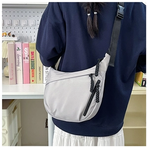 Detail view of grey nylon crescent bag with adjustable strap and durable black zipper pulls