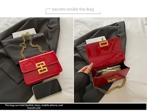 Detail view of red patent leather bag showing golden metal lock and internal storage capacity