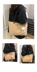 Detail of khaki pleated tote bag featuring a plush charm and slim black leather shoulder straps