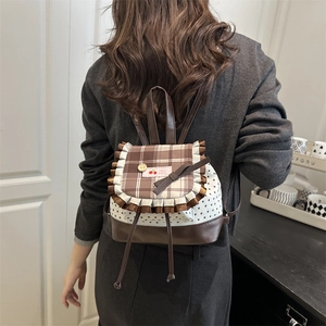 Sweet plaid backpack with cherry label, lace edges, and star pattern on a model's back