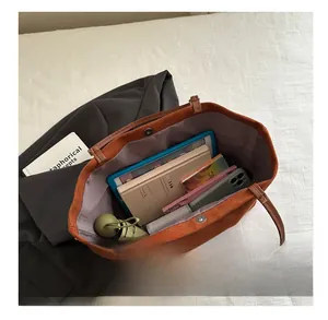 Deep brown suede tote bag showing internal storage for tablet, books and umbrella