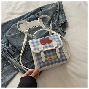 Détail du sac à dos d'école à carreaux bleus avec motif pomme rouge et bandoulières