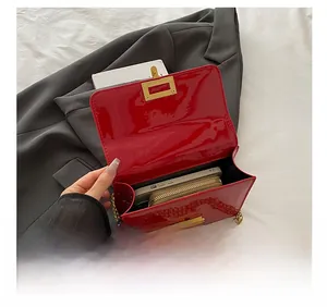 Internal view of red patent leather crossbody bag showing phone and wallet storage