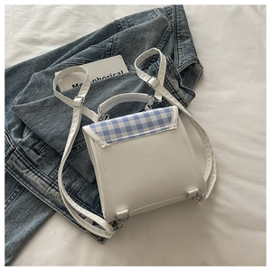 Détail d'un sac à dos en cuir PU blanc avec tissu à carreaux bleus et boucles en argent
