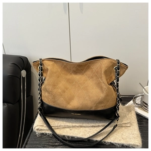 Detail of vintage tote bag featuring brown suede and black leather patchwork design