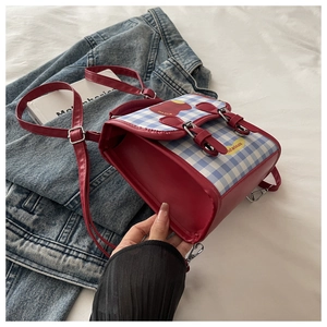 Mini sac à dos rouge avec rabat à carreaux bleus et détail cerise sur veste en jean
