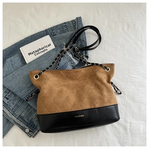 Detail of vintage quilted tote showing brown suede stitching and black leather bottom