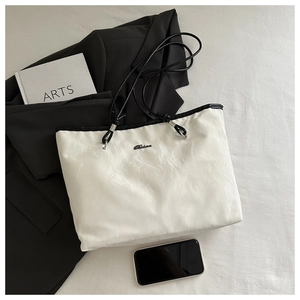 Macro view of white marble texture tote bag with black straps and minimalist accessories