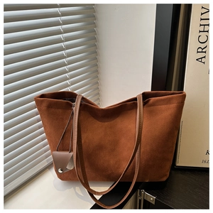 Close-up of deep brown suede tote bag with smooth texture and matching coin purse